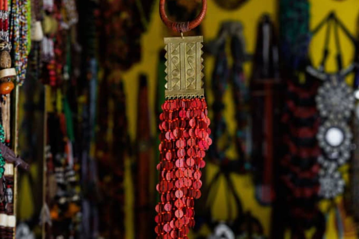 Collier artisanal à pendentif géométrique et franges rouges