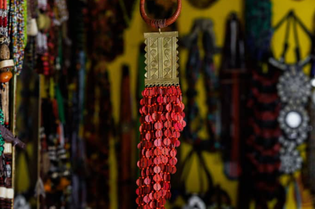 Collier artisanal à pendentif géométrique et franges rouges